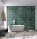 Modern bathroom with green tiled wall and white freestanding bathtub.