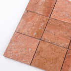 Close-up of red travertine tiles on a white background