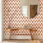 Room interior with a wooden bench, mirror, and patterned wall.