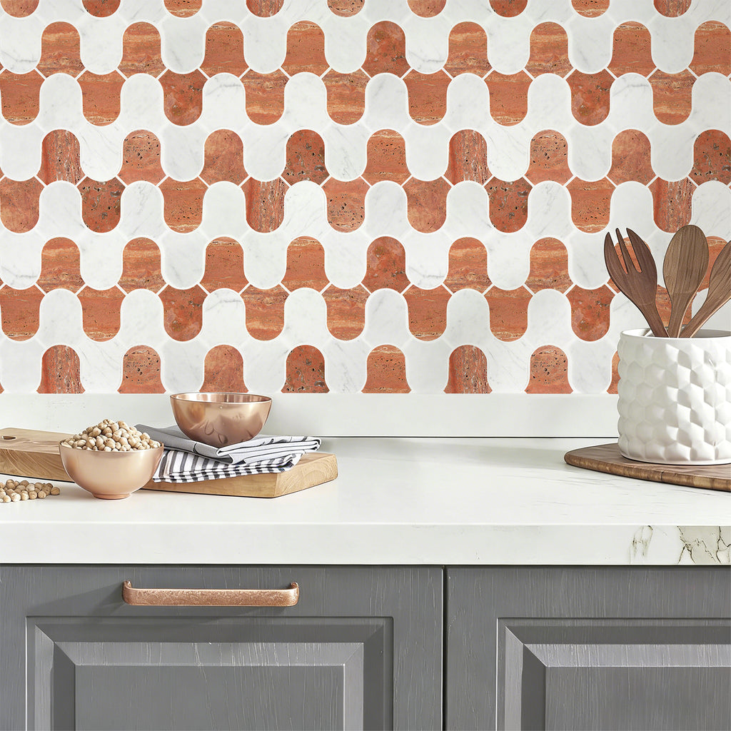 Kitchen counter with geometric patterned backsplash, gray cabinets, and kitchen utensils.