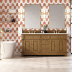 Bathroom with wooden vanity, mirrors, and patterned wallpaper