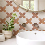 Bathroom with geometric tile pattern, white sink, and plant