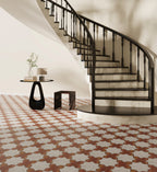 Staircase with decorative railing in a room with patterned floor tiles.