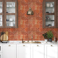 Modern kitchen with red patterned backsplash, white cabinets, and decorative elements.
