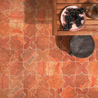 cross and star red travertine tiles on a floor, accompanied by a wooden table and decorative items.