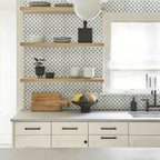Modern kitchen with mosaic tile backsplash, wooden shelves, and white cabinets.