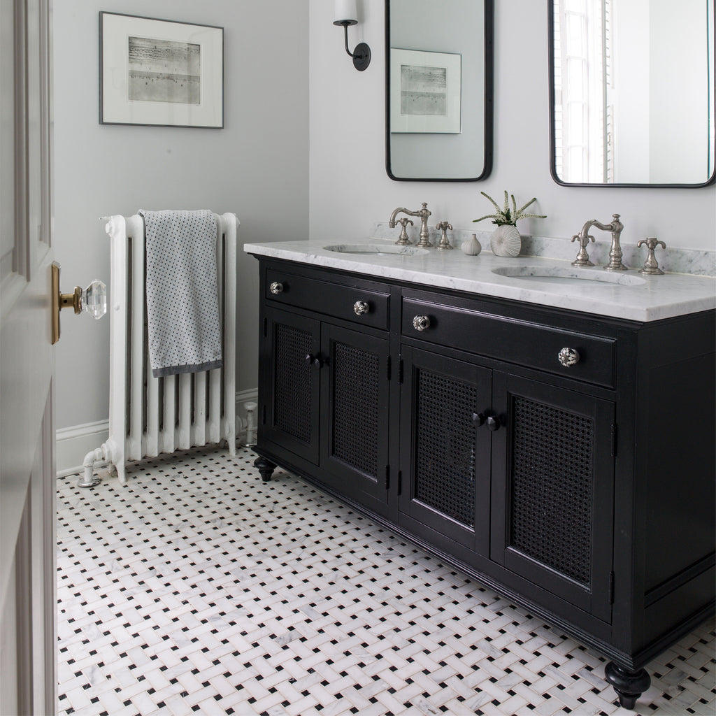 Bathroom with black vanity, white countertop, white tiled floor and decorative elements.