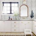 Bathroom with white vanity, mirror, and window with black trim.