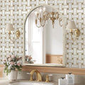 Bathroom vanity with gold fixtures, mirror, and decorative wall lights.