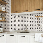 Modern kitchen with black and white tiled backsplash, wooden cabinets, and white countertops.