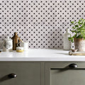 Kitchen counter with decorative vases and a plant against a geometric patterned wall.