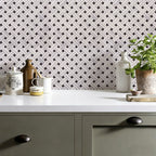 Kitchen counter with decorative vases and a plant against a geometric patterned wall.