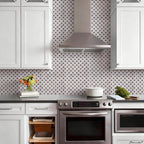 Modern kitchen with stainless steel appliances and geometric wall pattern