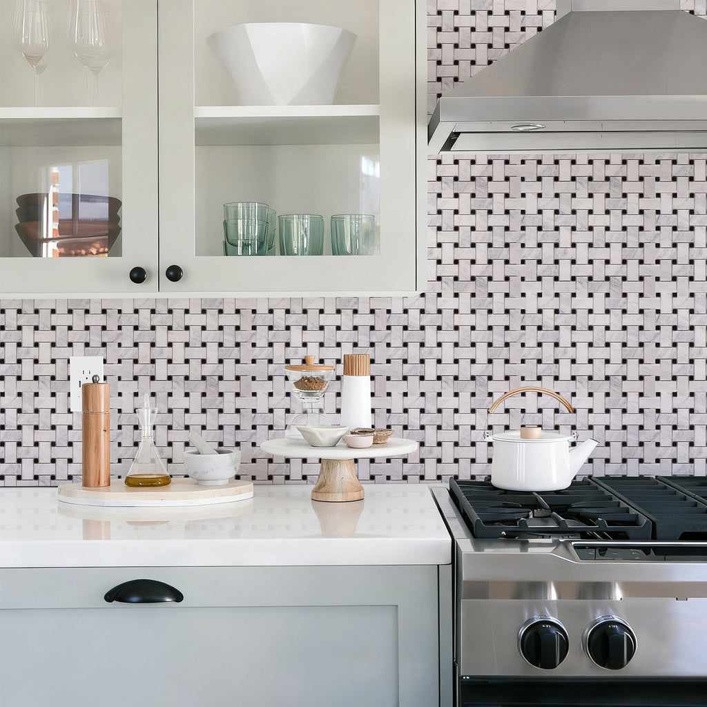 Modern kitchen with white cabinets, marble countertop, and stainless steel stove.