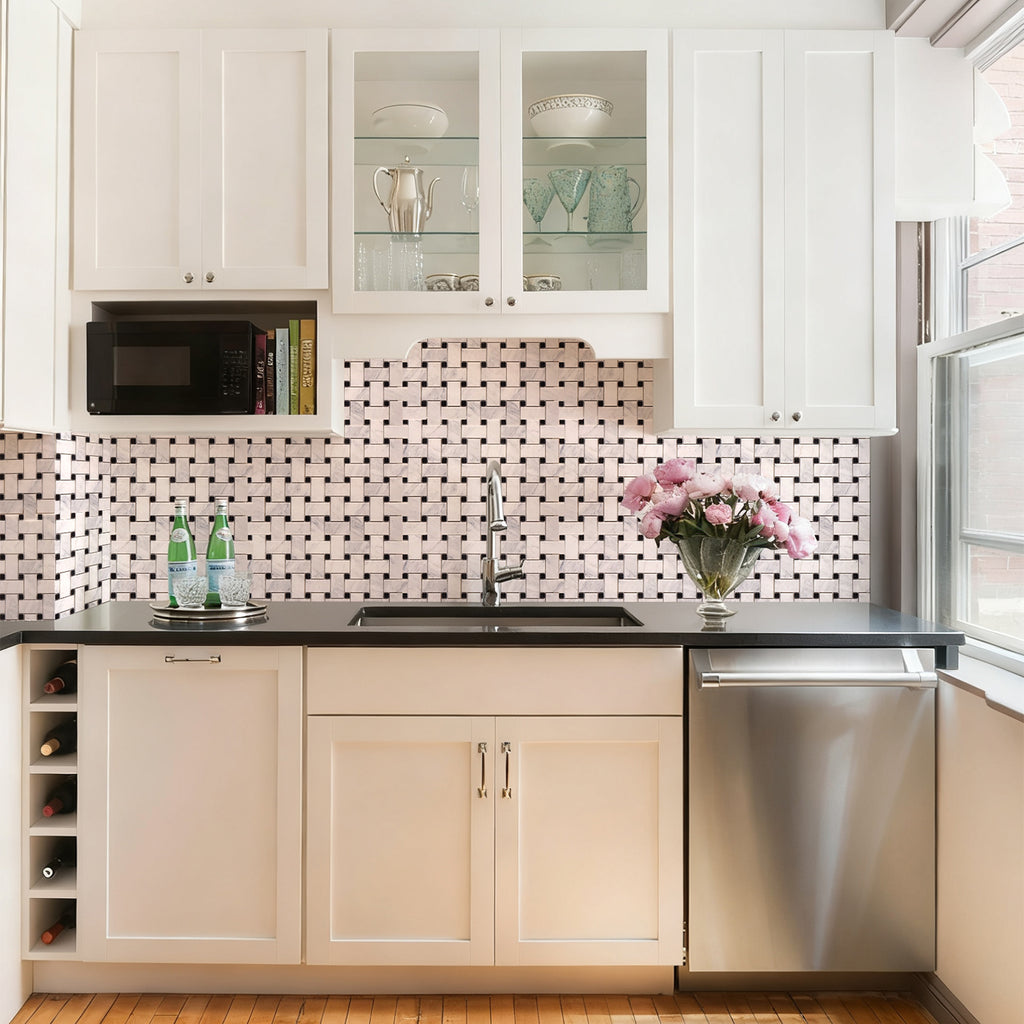 Modern kitchen with white cabinets, black countertop, and decorative tiles on the wall.