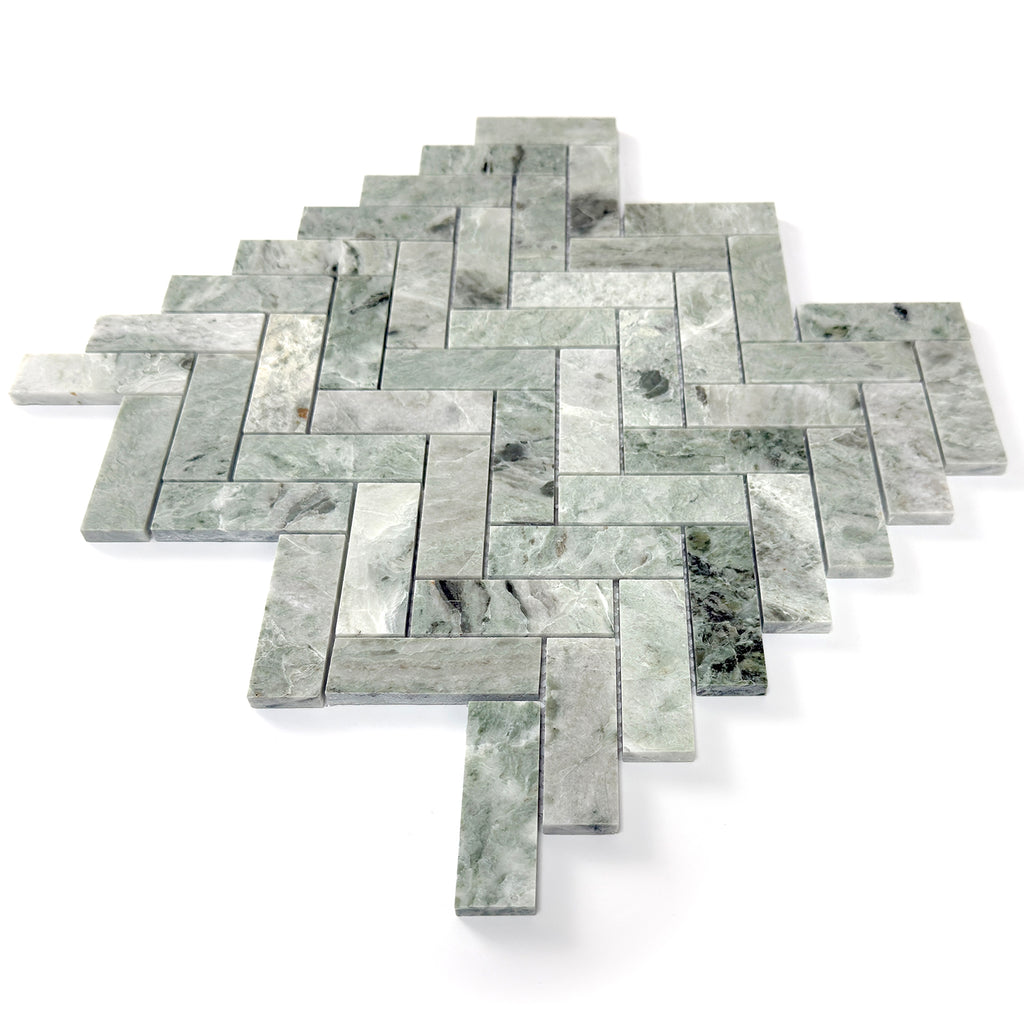 Green marble tiles arranged in a herringbone pattern on a white background