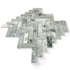 Green marble tiles arranged in a herringbone pattern on a white background