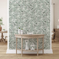 Room interior with a wooden console table against a wall with green herringbone patterned wallpaper.