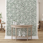 Room interior with a wooden console table against a wall with green herringbone patterned wallpaper.