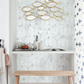 Decorative wall art with gold fish shapes on a light gray wall.