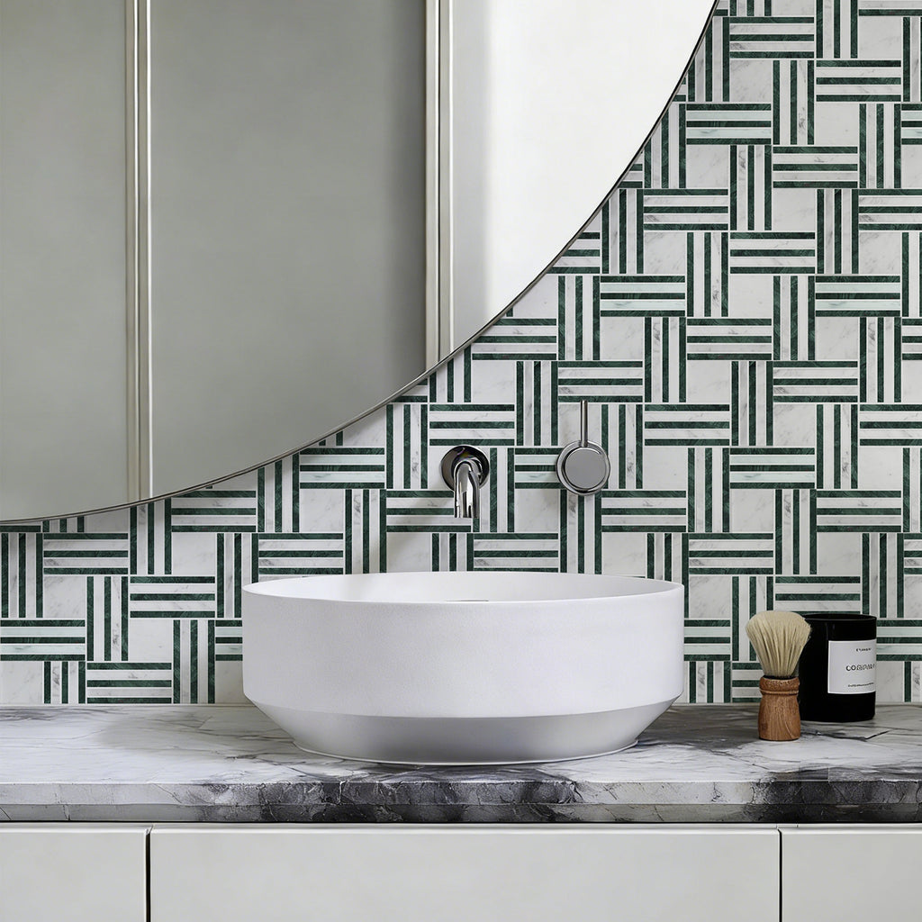Bathroom vanity with a round white sink, marble countertop, and geometric patterned wall tiles.