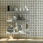 Kitchen with white shelves against a black and white tiled wall