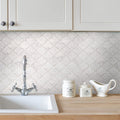 Kitchen with a patterned backsplash, sink, and decorative jars on the counter.