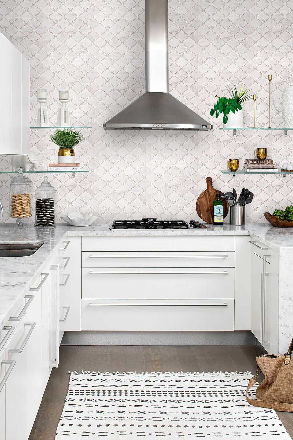 Modern kitchen with white cabinets, tiled backsplash, and stainless steel appliances.