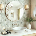 Bathroom with round mirror, sink, and decorative elements on a tiled wall.