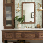Bathroom vanity with wooden cabinets, mirror, and decorative items.